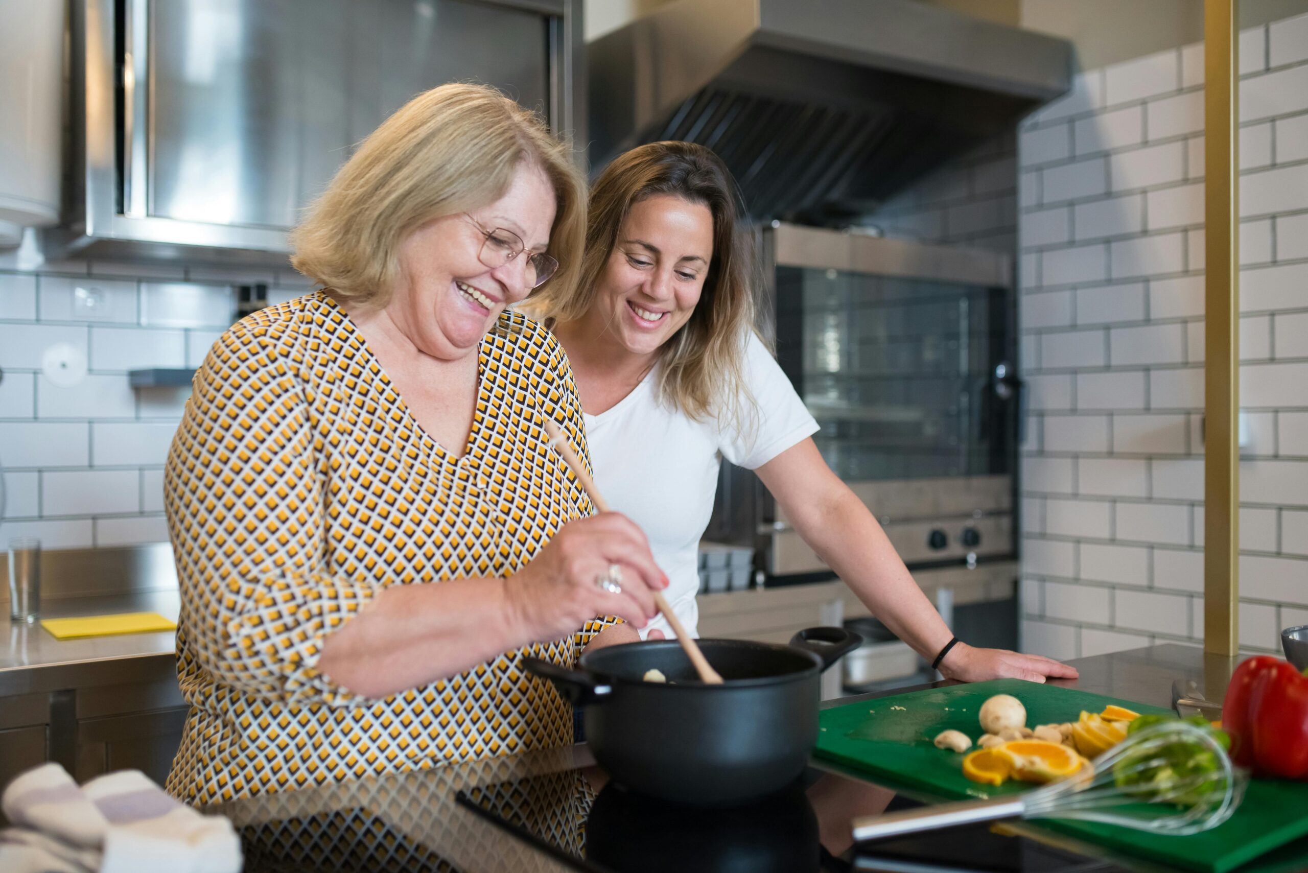 A joyful mother and daughter bonding over cooking in a modern kitchen.